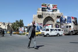 A man walks along a street decorated with posters depicting Syria's President Bashar al-Assad, ahead of the May 26 presidential election, in Damascus, Syria May 22, 2021. REUTERS/Yamam al Shaar